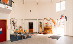 Die Eingangshalle bietet viel Raum zum Spielen und Sitzmöglichkeiten.  | © Caritas München und Freising e.V. | Benjamin Asher